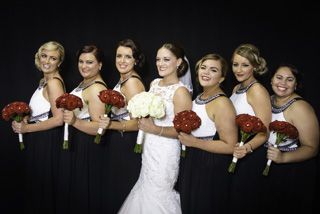 Bride and 6 bridesmaids with red flowers